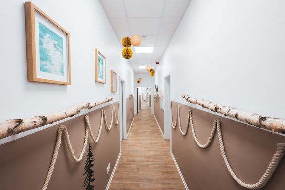 Langer, heller Flur mit Holzverkleidung und Dekorationen an den Wänden.